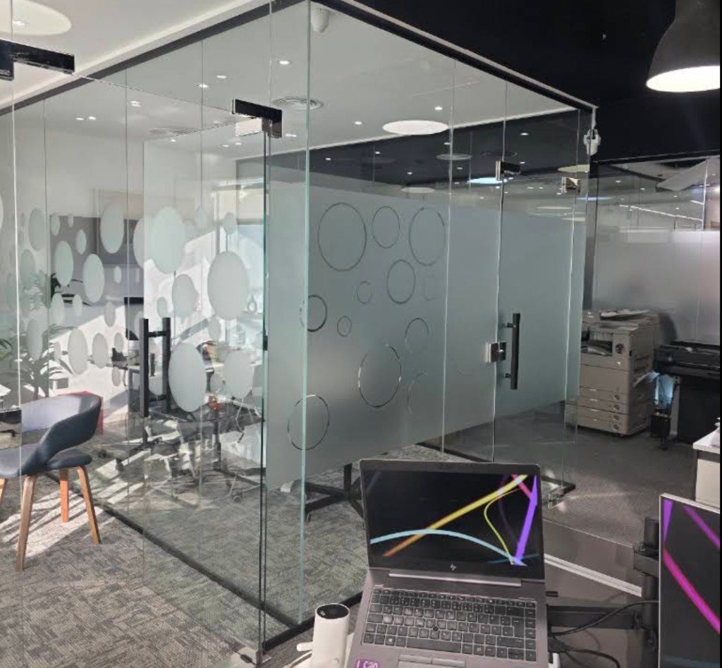 Modern glass meeting rooms and workstations inside the Alnahrain office